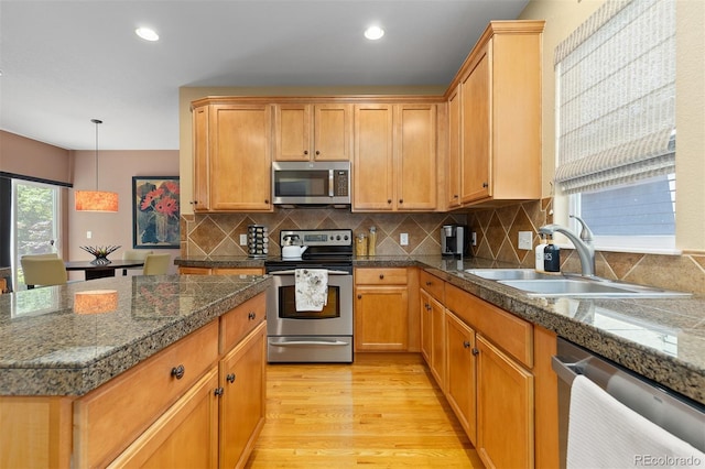 2488 Lake Vista Dr, Broomfield, CO 80023 - kitchen with stainless steel appliances, tile counters, light wood finished floors, backsplash, and recessed lighting