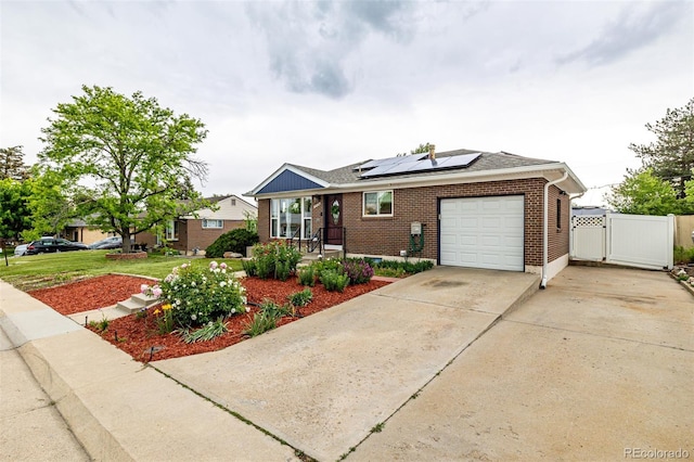 10478 Ogden St, Northglenn, CO 80233 - ranch-style house featuring brick siding, an attached garage, solar panels, a gate, and concrete driveway