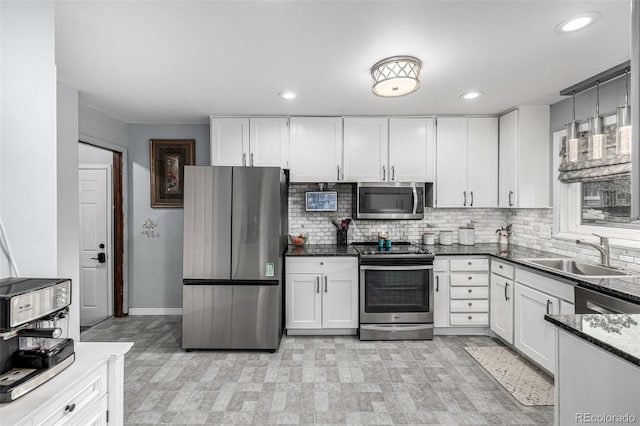10478 Ogden St, Northglenn, CO 80233 - kitchen featuring appliances with stainless steel finishes, a sink, white cabinets, decorative backsplash, and recessed lighting