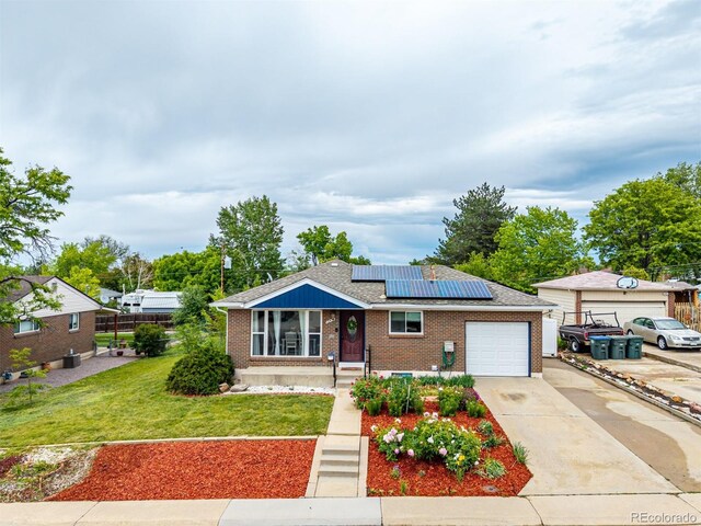 10478 Ogden St, Northglenn, CO 80233 - view of front of house featuring solar panels, brick siding, a front lawn, and a garage