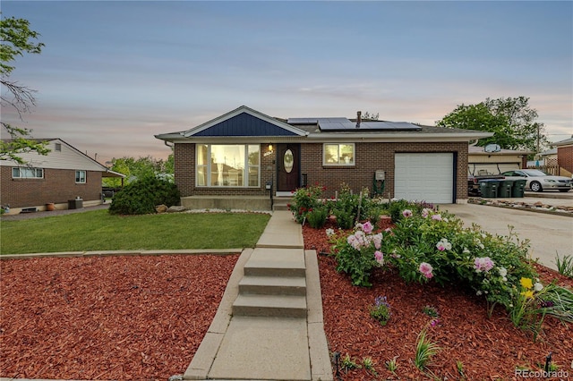 10478 Ogden St, Northglenn, CO 80233 - view of front of property featuring an attached garage, solar panels, brick siding, driveway, and a front yard