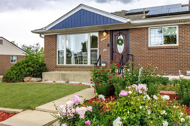 10478 Ogden St, Northglenn, CO 80233 - view of front of home featuring brick siding, solar panels, and a front lawn
