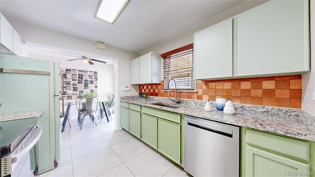 kitchen featuring appliances with stainless steel finishes, white cabinetry, tasteful backsplash, sink, and light stone counters