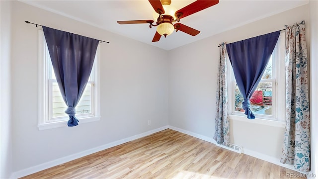 empty room featuring light hardwood / wood-style floors, ceiling fan, and a healthy amount of sunlight