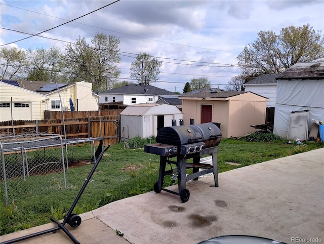 view of yard with a storage shed, an outbuilding, and a patio area