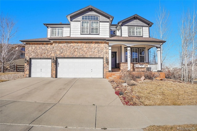 view of front facade featuring a garage, stone siding, a porch, and driveway