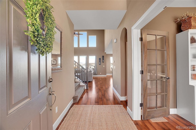 8726 Gardenia Cir, Arvada, CO 80005 - entryway with wood finished floors, stairway, arched walkways, and baseboards