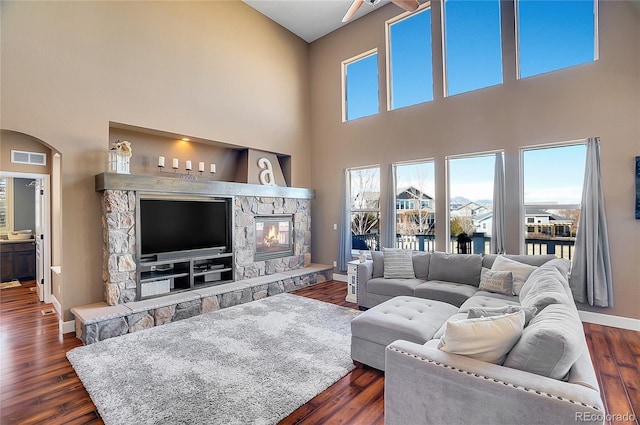 8726 Gardenia Cir, Arvada, CO 80005 - living room featuring a high ceiling, dark wood-style floors, baseboards, and a fireplace