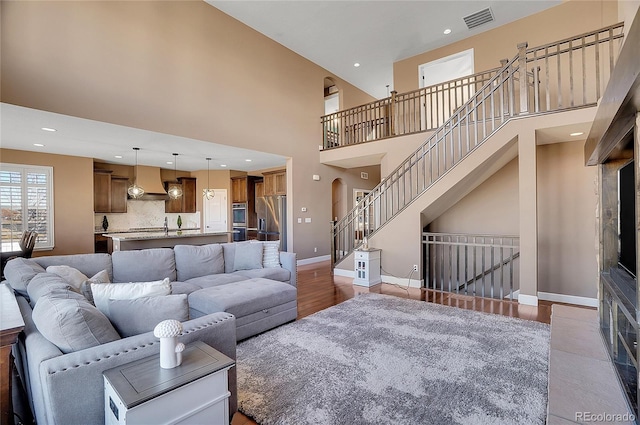 8726 Gardenia Cir, Arvada, CO 80005 - living room with wood finished floors, baseboards, a high ceiling, and recessed lighting