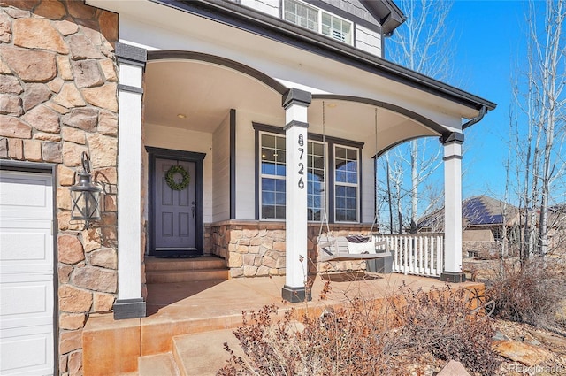 8726 Gardenia Cir, Arvada, CO 80005 - doorway to property featuring stone siding and covered porch