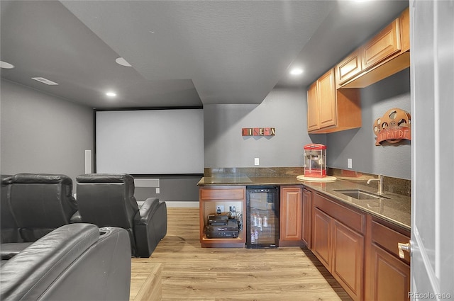 8726 Gardenia Cir, Arvada, CO 80005 - home theater featuring beverage cooler, bar with sink, recessed lighting, and light wood finished floors
