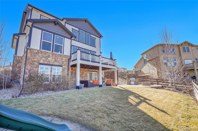 8726 Gardenia Cir, Arvada, CO 80005 - back of house featuring stone siding, a wooden deck, an outdoor hangout area, and a patio area
