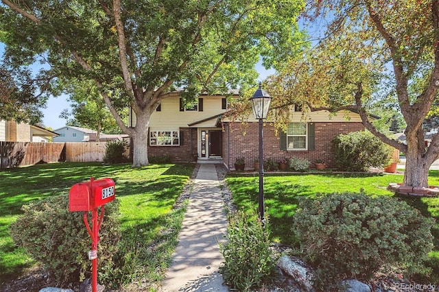 view of front of property featuring brick siding, a front yard, and fence