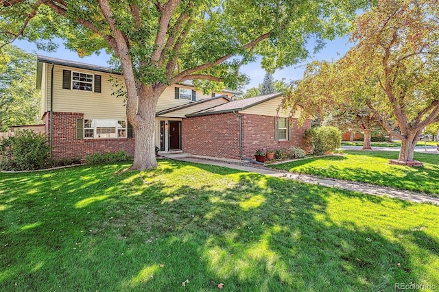 view of front of home featuring brick siding and a front lawn