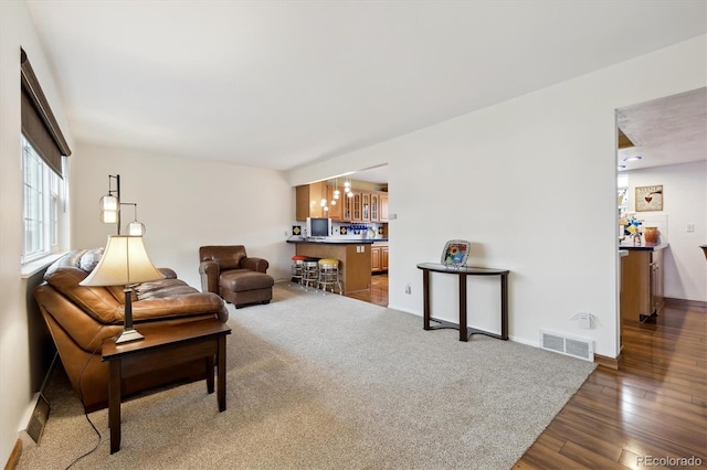 living room with visible vents, baseboards, and wood finished floors