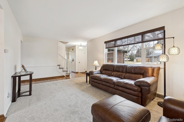 living room featuring stairs, carpet, and baseboards