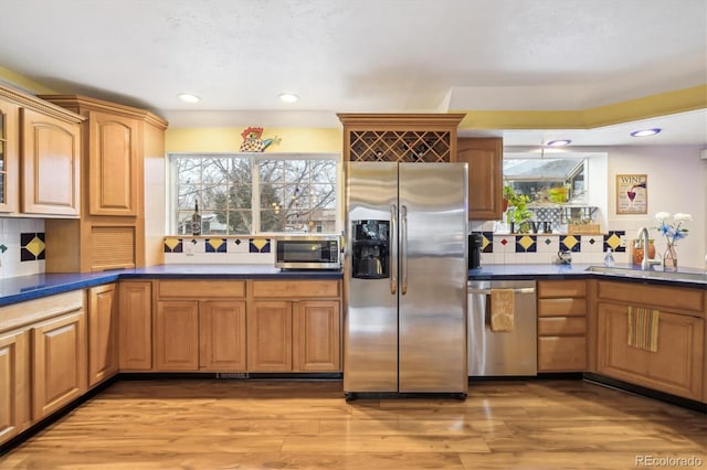 kitchen with backsplash, recessed lighting, appliances with stainless steel finishes, light wood-style floors, and a sink