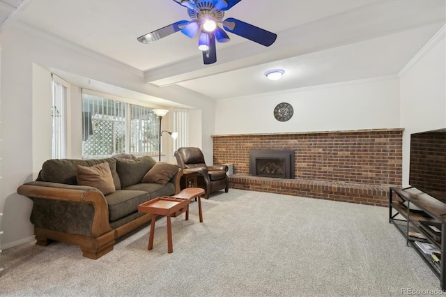 carpeted living area with ceiling fan, beamed ceiling, a brick fireplace, and ornamental molding