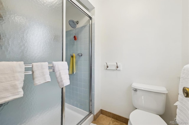 bathroom featuring tile patterned floors, baseboards, toilet, and a shower stall