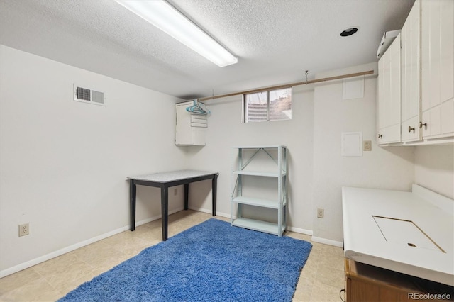 interior space with baseboards, visible vents, and a textured ceiling