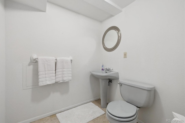 half bathroom featuring toilet and baseboards