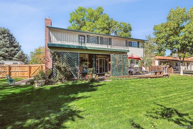 back of property featuring a yard, fence, and a chimney