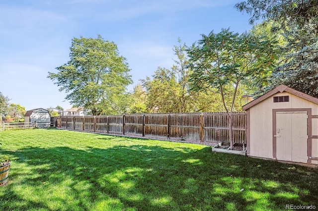 view of yard featuring an outbuilding, a fenced backyard, and a shed