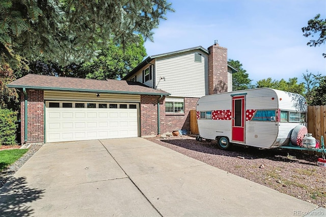 view of front of house with fence, a chimney, concrete driveway, a garage, and brick siding