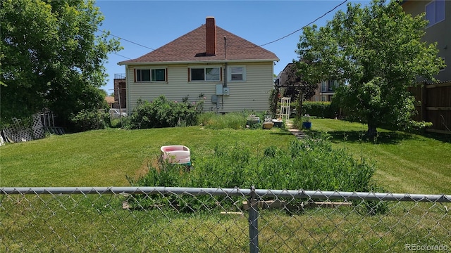 rear view of house featuring a lawn