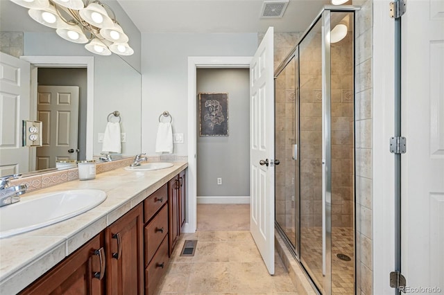 full bathroom with a shower stall, double vanity, and baseboards