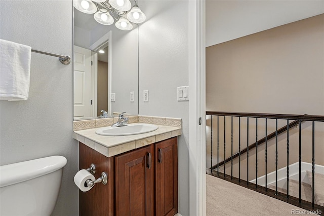 bathroom with vanity, toilet, and a chandelier