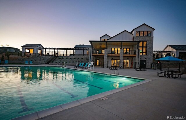 8628 Hotchkiss St, Littleton, CO 80125 - pool at dusk with a patio, fence, and a community pool
