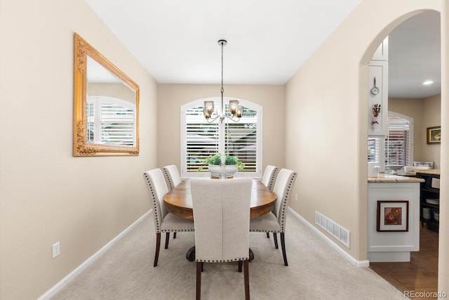 6772 Tiger Tooth, Littleton, CO 80124 - dining space with a chandelier, arched walkways, and light carpet