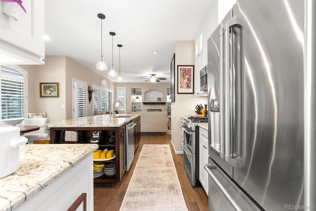 6772 Tiger Tooth, Littleton, CO 80124 - kitchen featuring appliances with stainless steel finishes, ceiling fan, open floor plan, dark wood-style floors, and white cabinetry