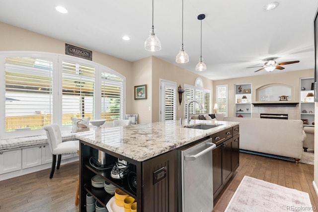 6772 Tiger Tooth, Littleton, CO 80124 - kitchen featuring stainless steel dishwasher, dark brown cabinetry, open floor plan, hardwood / wood-style floors, and ceiling fan