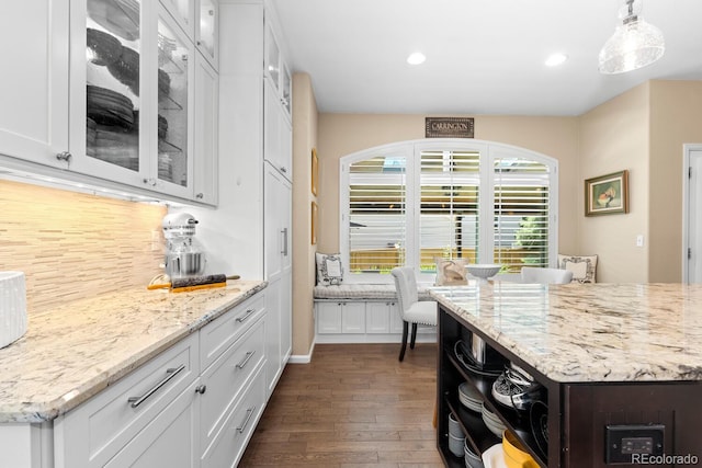 6772 Tiger Tooth, Littleton, CO 80124 - kitchen with white cabinetry, dark wood-style flooring, decorative backsplash, recessed lighting, and light stone countertops