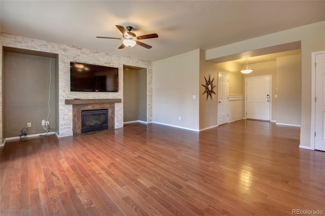 5947 Cumbre Vista Way, Colorado Springs, CO 80924 - unfurnished living room with a ceiling fan, wood finished floors, and a stone fireplace