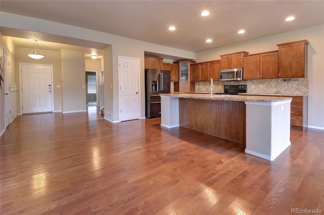 5947 Cumbre Vista Way, Colorado Springs, CO 80924 - kitchen featuring stainless steel microwave, high quality fridge, range with electric cooktop, brown cabinets, and dark wood-style floors