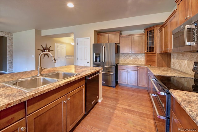 5947 Cumbre Vista Way, Colorado Springs, CO 80924 - kitchen with appliances with stainless steel finishes, light wood-type flooring, brown cabinetry, decorative backsplash, and recessed lighting