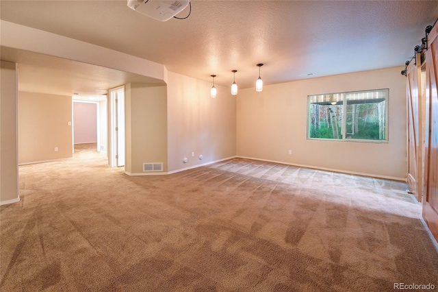 5947 Cumbre Vista Way, Colorado Springs, CO 80924 - spare room with light carpet, a barn door, and a textured ceiling