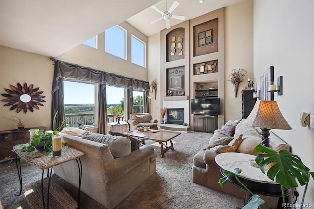 living area featuring built in shelves, a fireplace, a high ceiling, and ceiling fan