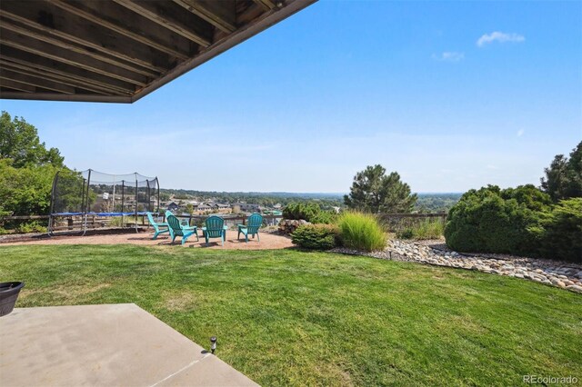 view of yard featuring a trampoline and a patio