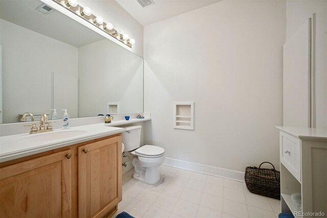 bathroom featuring toilet, baseboards, visible vents, and vanity