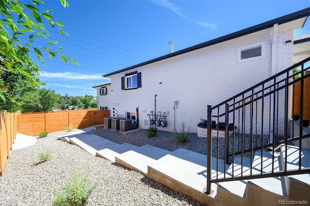 4901 W 11th Ave, Denver, CO 80204 - view of side of home with brick siding, a fenced backyard, and a patio