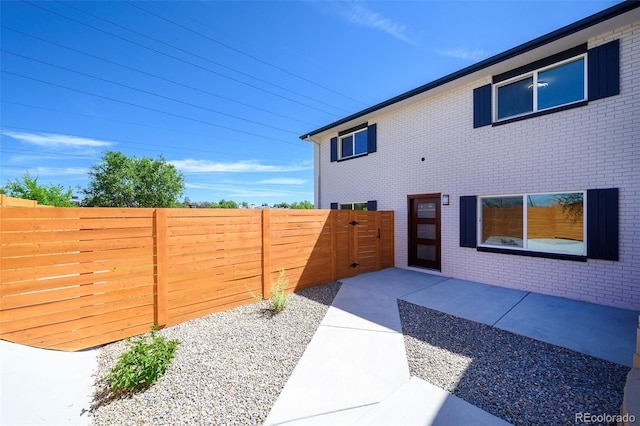 4901 W 11th Ave, Denver, CO 80204 - view of side of property featuring brick siding, a gate, and a patio
