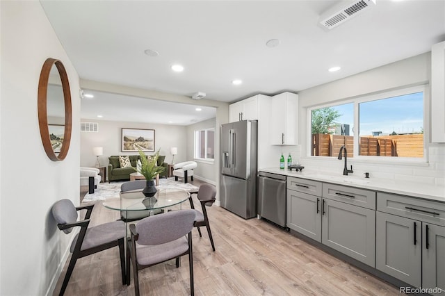 4901 W 11th Ave, Denver, CO 80204 - kitchen with stainless steel appliances, light wood finished floors, gray cabinetry, tasteful backsplash, and recessed lighting