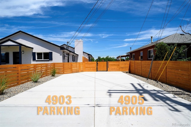 4901 W 11th Ave, Denver, CO 80204 - view of side of property with a fenced front yard, brick siding, and a gate