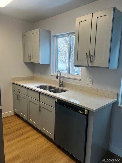 kitchen featuring a sink, light wood-style flooring, gray cabinets, and dishwasher