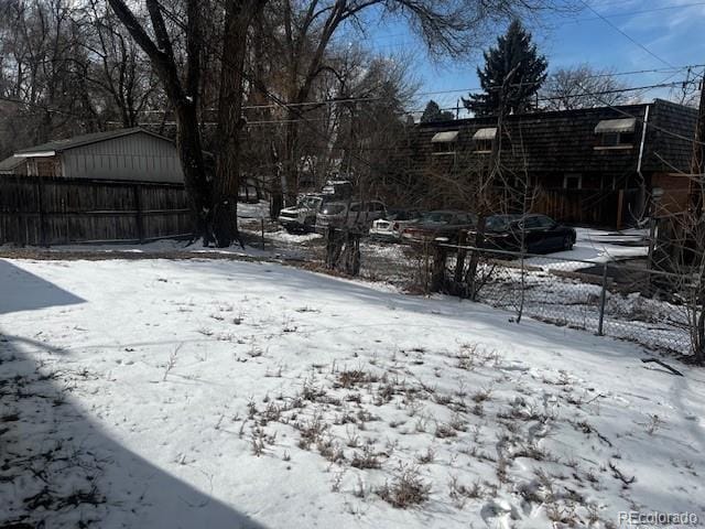 yard layered in snow with fence