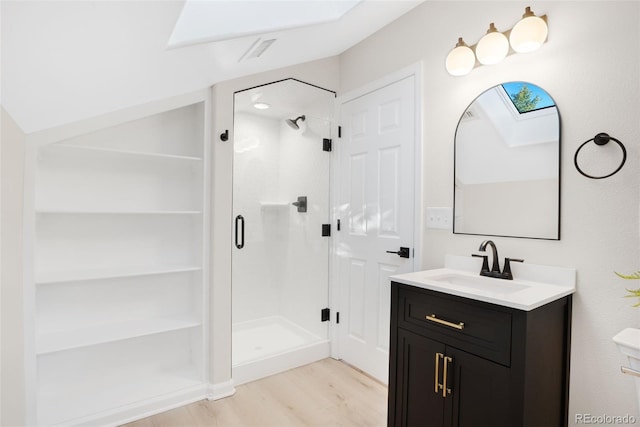 bathroom with a shower with door, vanity, vaulted ceiling, and hardwood / wood-style flooring